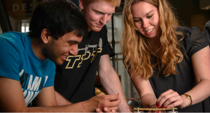 three college students working on electronics