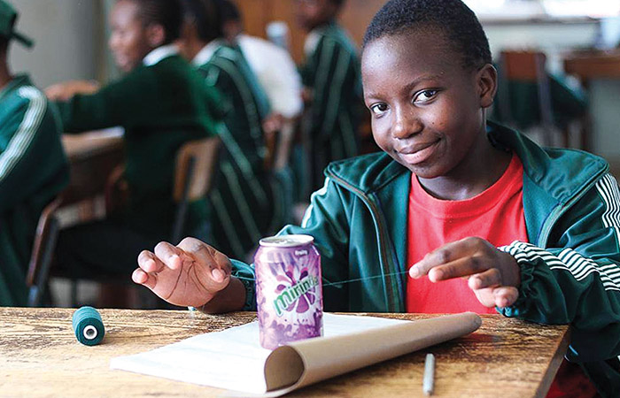 a young african girl doing a science experiment