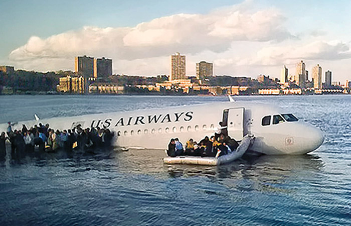 passenger airplane floating on the hudson river as passengers escape