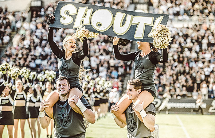 cheerleaders holding a sign that says shout