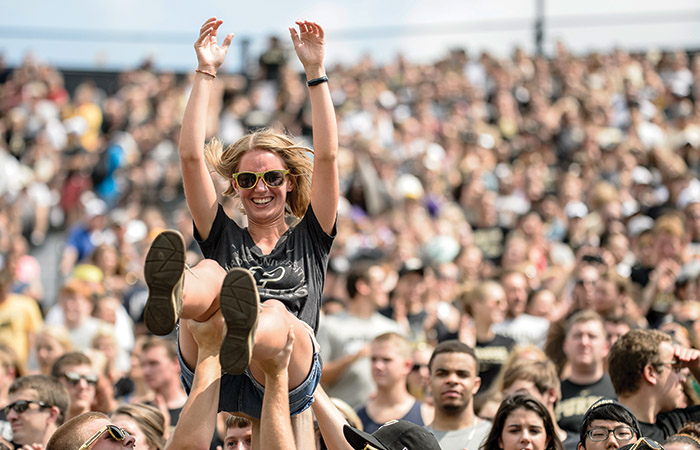 a girl is lifted up after Purdue scores a touchdown