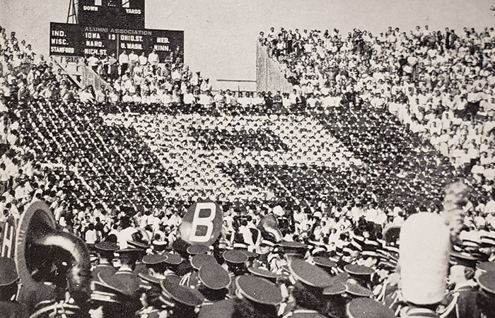 fans hold up cards at a football game creating a huge block p