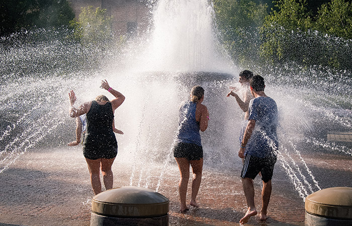 students run through a fountain