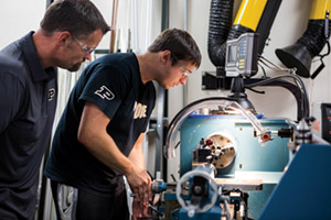 Norvin Bruns, biomedical  engineering shop manager, supervises Michael Dziekan as he  fabricates parts for the prosthesis. 