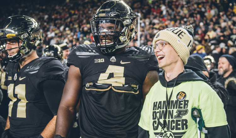 Tyler Trent stands on the sidelines with Boilermaker linebacker Ja’Whaun Bentley.