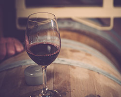 a glass of wine on a wine barrel