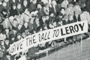 Football fans hold a banner that says give the ball to Leroy.