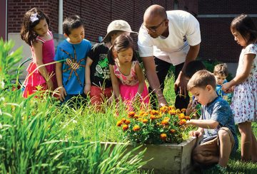 an adult and children looking at plants growing in the raised beds of Marriott Garden