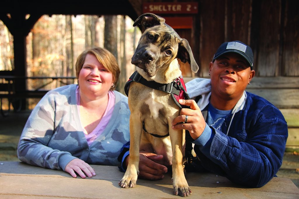 two adults and their dog