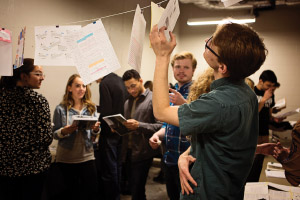 students looking at papers hanging on a string