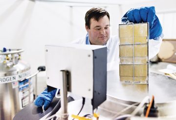 A scientist inspects his equipment and experiment