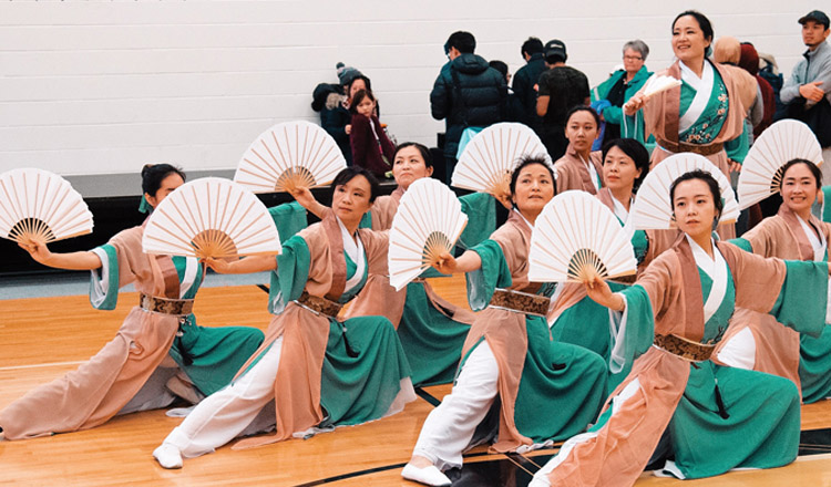 asian women performing a traditional dance with fans