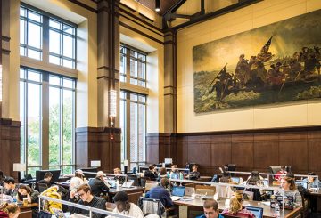 A large painting of Washington Crossing the Delaware hangs on the wall overlooking dozens of students studying